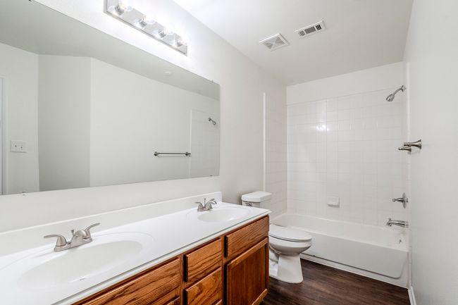 Full bath with wood finished floors, double vanity, and shower / tub combination | Image 24