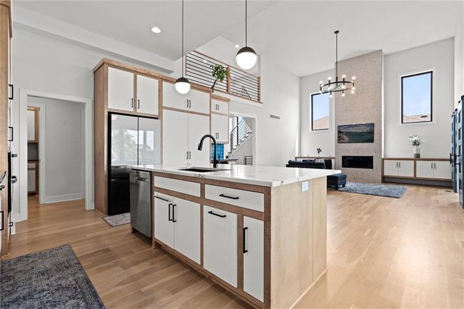 Kitchen with light wood-style flooring, dishwasher, pendant lighting, white cabinets, and recessed lighting | Image 14