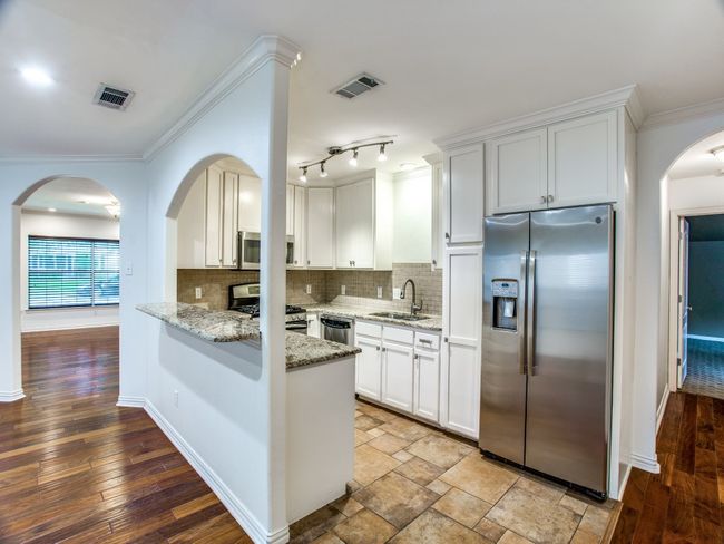 Kitchen featuring decorative backsplash, crown molding, appliances with stainless steel finishes, and a sink | Image 10
