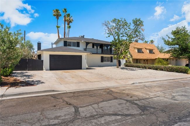 Front of property with a balcony, concrete driveway, an attached garage, and stucco siding | Image 56