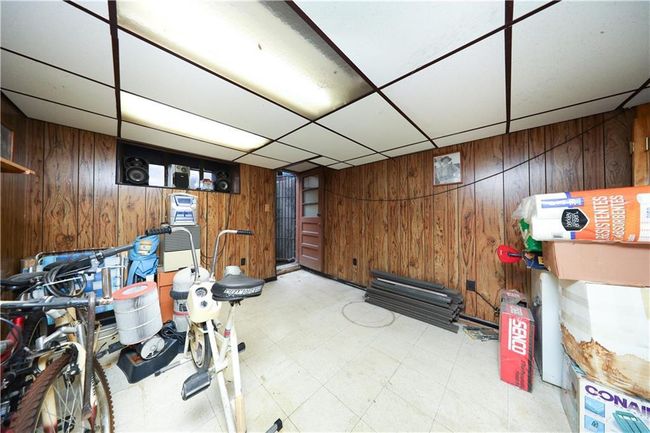 Finished basement with wood walls, tile patterned floors, and a drop ceiling | Image 23