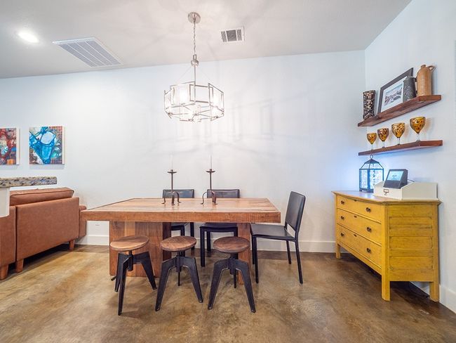 Dining space with concrete floors and a chandelier | Image 9