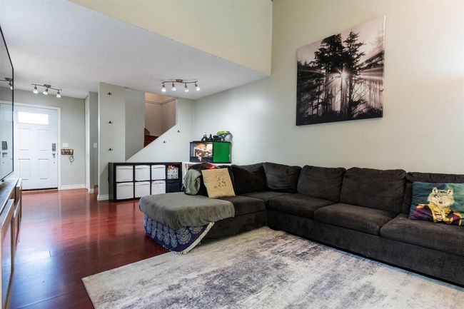 Living room featuring wood finished floors, rail lighting, and stairway | Image 7