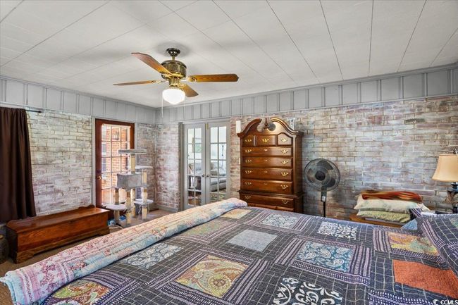 Bedroom featuring brick wall, ceiling fan, and french doors | Image 25