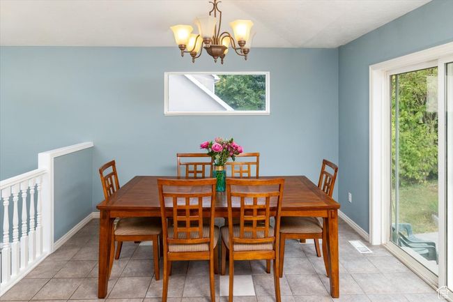Dining area with an inviting chandelier and light tile patterned floors | Image 11