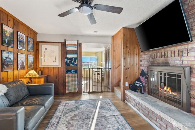 The lower level of this home has warmth and charm with its rich wood walls, stone accents, and a classic brick fireplace. These natural elements come together to create a cozy and inviting atmosphere, perfect for relaxing or gathering with family and friends | Image 15