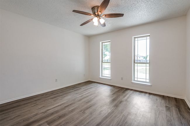 Unfurnished room with a textured ceiling, dark wood-style floors, and ceiling fan | Image 17