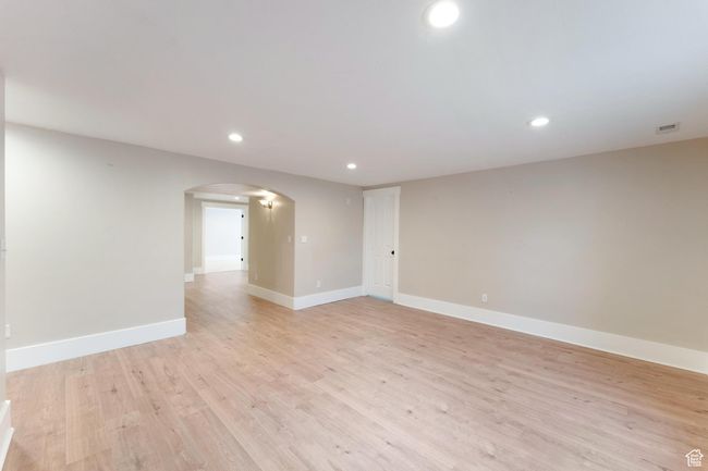 Basement family room featuring arched walkways, recessed lighting, and light wood-type flooring | Image 31