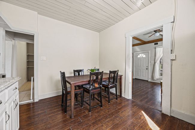 Dining room with wood ceiling, baseboards, ceiling fan, and dark wood-style flooring | Image 13