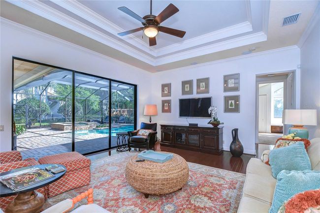 Step into this exquisite living area featuring elegant tray ceilings and a view that’s unbelievable. | Image 15