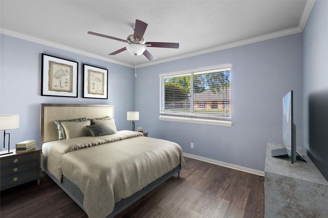 Bedroom with dark wood-style flooring, crown molding, baseboards, and ceiling fan | Image 14