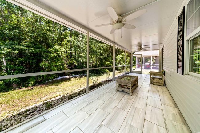 Sunroom / solarium with a ceiling fan | Image 30