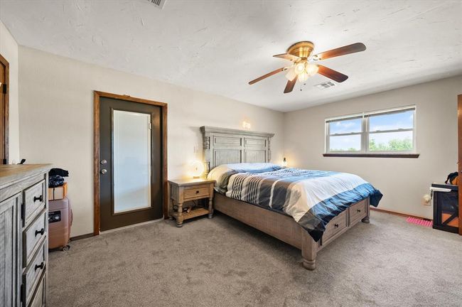 Bedroom with light carpet, baseboards, and ceiling fan | Image 20