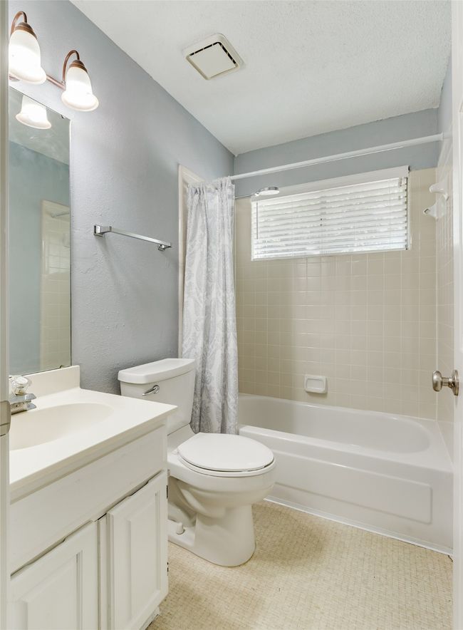 Bathroom featuring vanity, toilet, shower / bath combo with shower curtain, and visible vents | Image 24