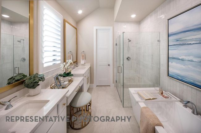Bathroom featuring double vanity, a shower stall, a garden tub, vaulted ceiling, and recessed lighting | Image 19