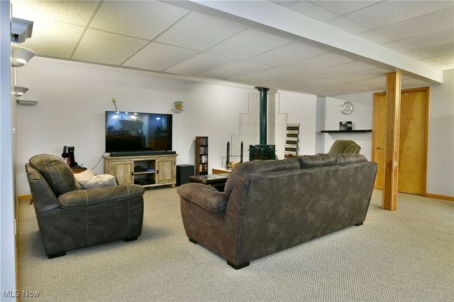 Carpeted living room with a wood stove and a drop​​‌​​​​‌​​‌‌​‌‌​​​‌‌​​‌‌​‌​​​​​‌ ceiling | Image 37
