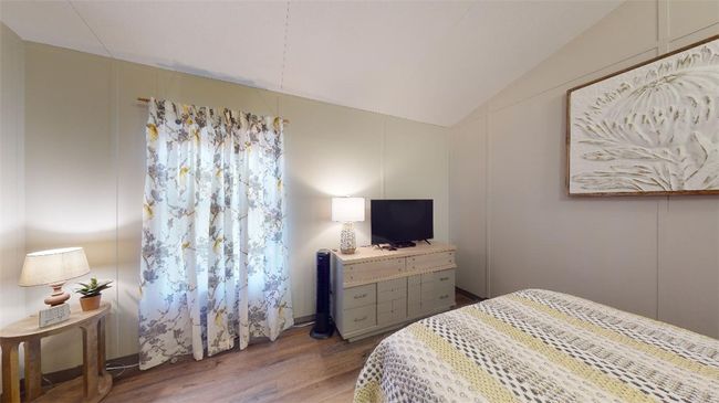 Bedroom with wood finished floors and lofted ceiling | Image 34