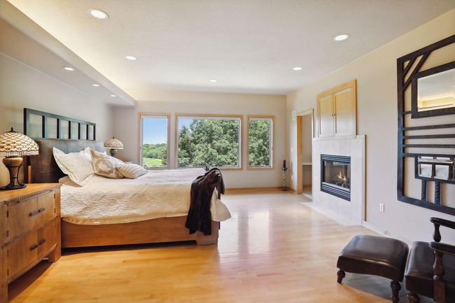 Retreat to this glorious owners suite. Expansive windows with private, lake views! Double sided fireplace shared with luxurious, primary bathroom! | Image 23