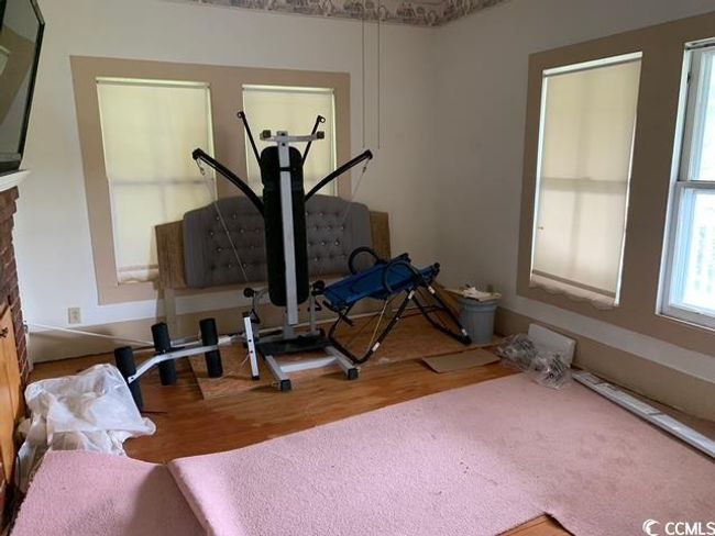 Room with wood finished floors and a fireplace | Image 18