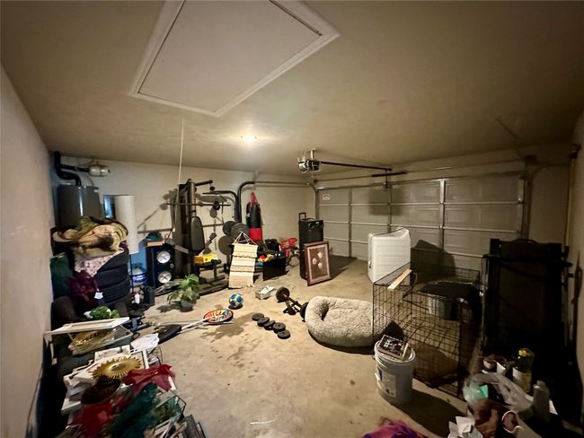 Garage featuring a garage door opener and water heater | Image 9