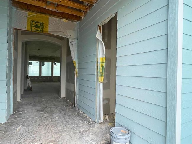 Another look at the signature covered breezeway leading into the home. This thoughtful layout not only adds curb appeal and storage convenience but also sets the tone for elevated coastal living with every detail designed for form and function. | Image 26