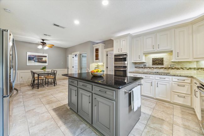 The stone tile floors (previously seen in the living and dining rooms) are carried throughout the common areas downstairs. | Image 10