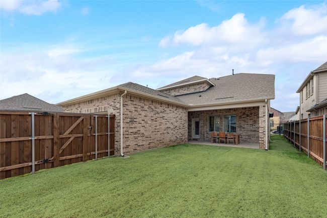 Back of house with a gate, brick siding, a fenced backyard, and a lawn | Image 28