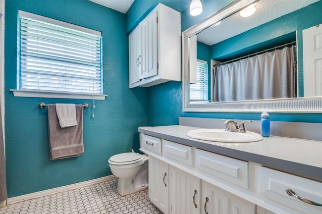 Full bath with vanity, tile patterned floors, baseboards, toilet, and a shower with shower curtain | Image 20