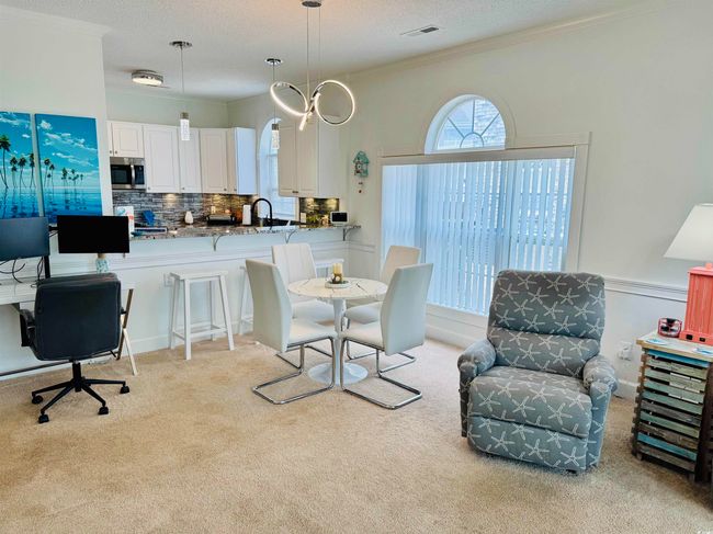 Dining room with light carpet, crown molding, and a textured ceiling | Image 22