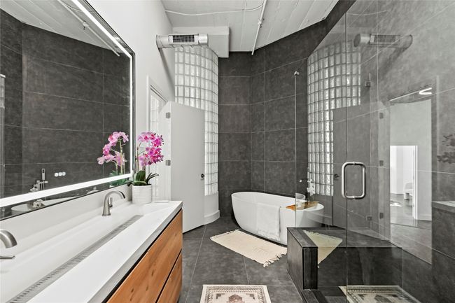 Full bathroom featuring tile patterned floors, a freestanding bath, tile walls, vanity, and a stall shower | Image 28