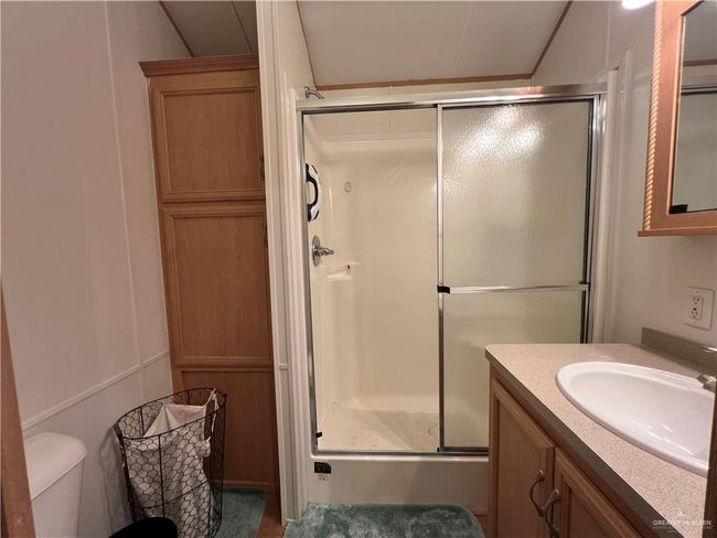 Bathroom featuring vanity, toilet, and an enclosed shower | Image 7