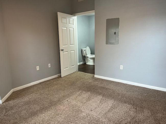 Unfurnished bedroom with electric panel, baseboards, and carpet floors | Image 14