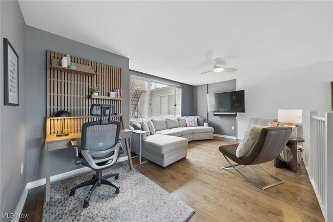 Living room with wood finished floors, baseboards, and a ceiling fan | Image 33