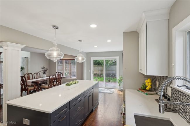 Kitchen featuring recessed lighting, a kitchen island, white cabinets, a sink, and dark wood-style floors | Image 20