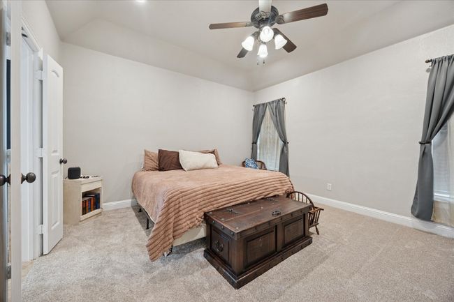 Bedroom featuring light colored carpet, baseboards, and ceiling fan | Image 11