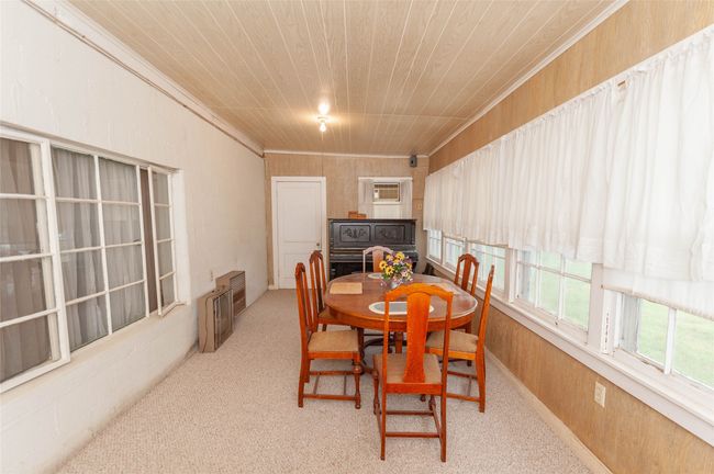 Dining area with wood walls, carpet flooring, wood ceiling, and crown molding | Image 22