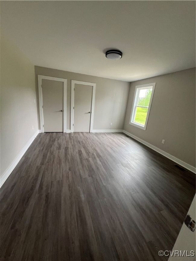 Unfurnished bedroom featuring baseboards and dark wood finished floors | Image 22