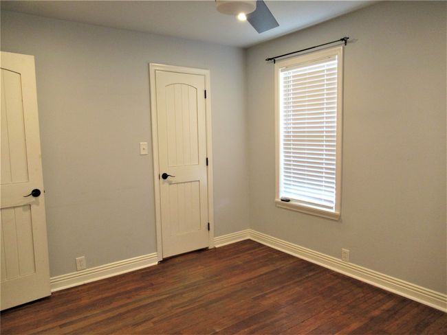 Unfurnished room with baseboards, dark wood-style flooring, and a ceiling fan | Image 16