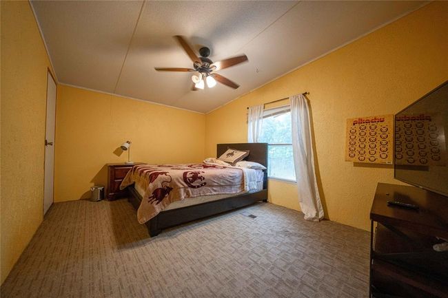 Bedroom with carpet floors, ceiling fan, and vaulted ceiling | Image 22