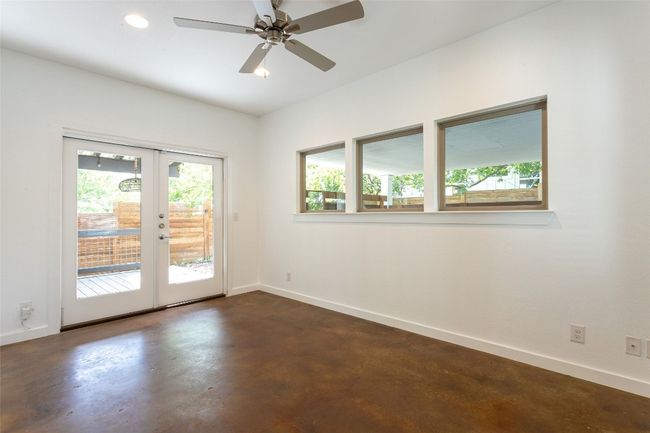 Spare room featuring finished concrete flooring, french doors, ceiling fan, and recessed lighting | Image 13