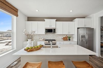 (Photo of model home, finishes will vary) Enjoy plenty of seating at the kitchen island and dining area adjacent to the kitchen. Perfect for entertaining or having a family meal together. | Image 1