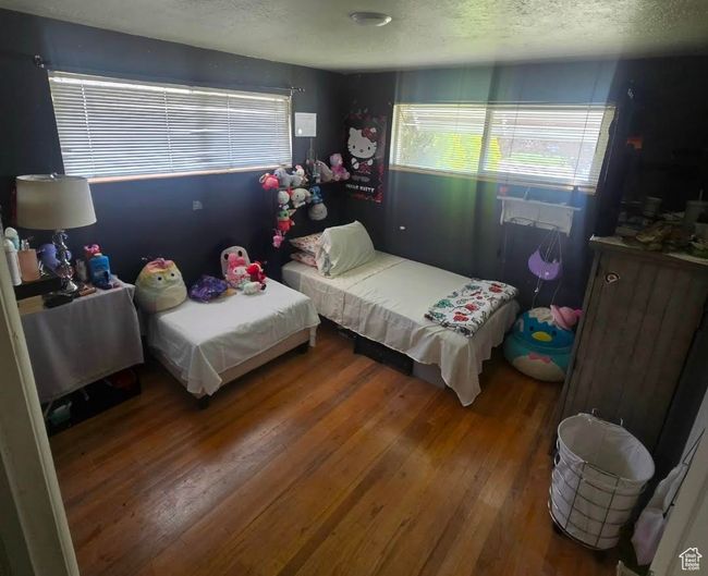 Bedroom with wood finished floors and a textured ceiling | Image 11