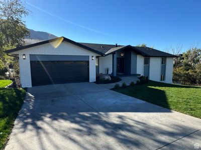 View of front of house featuring a mountain view, a front lawn, and a garage | Image 2