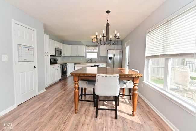 dining room with a chandelier, light wood-style floors, and baseboards | Image 14