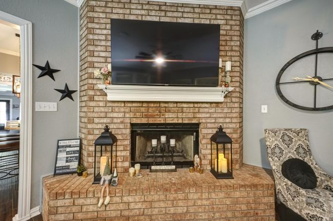 Room details featuring ornamental molding and a brick fireplace | Image 11