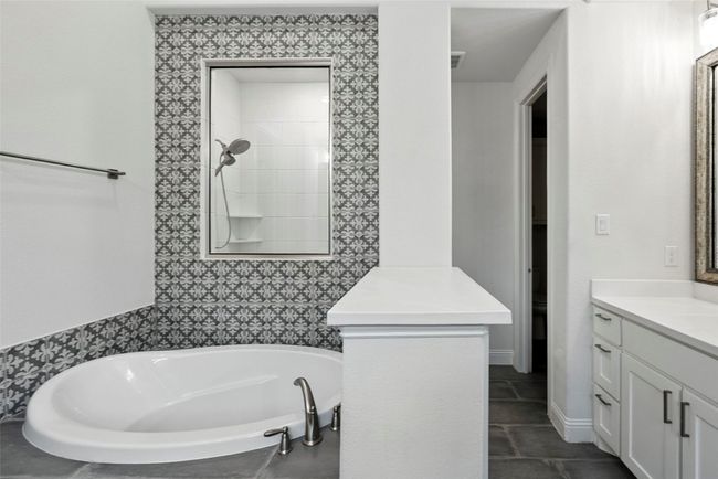 Bathroom featuring vanity, a bath, tile patterned floors, and tiled shower | Image 24