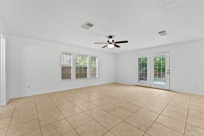 Unfurnished room with a ceiling fan, plenty of natural light, light tile patterned floors, and a textured ceiling | Image 6