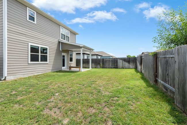 Fenced backyard with a patio area | Image 39