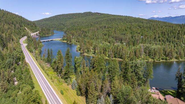 Drone / aerial view of a heavily wooded area and a water and mountain view | Image 51