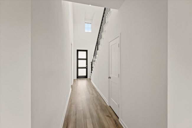 Hallway featuring a high ceiling and wood finished floors | Image 4